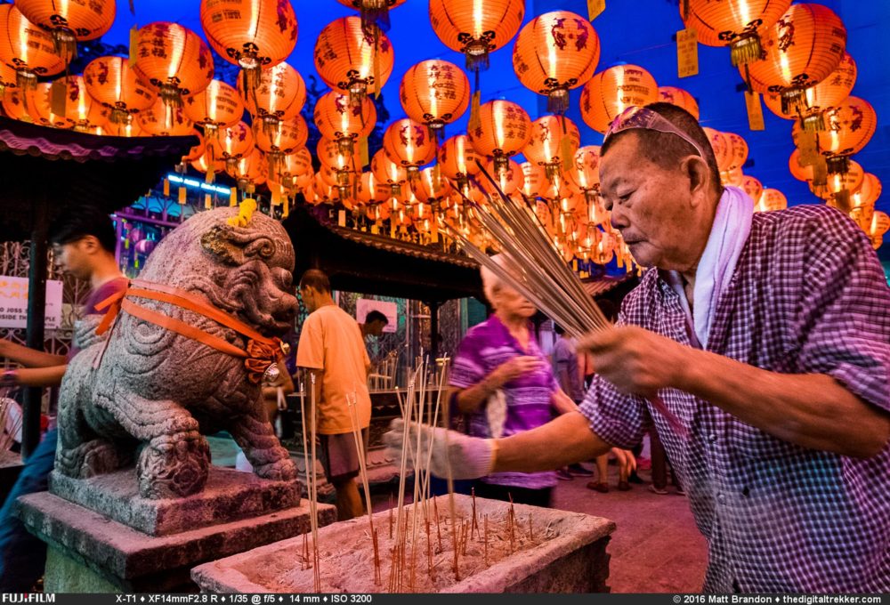 A temple volunteer pick up the older josh sticks. He needs to leave room for the hundreds more that will be left by the worshipers to come. Early morning at Kuan Im Teng (廣福宮/觀音亭). 