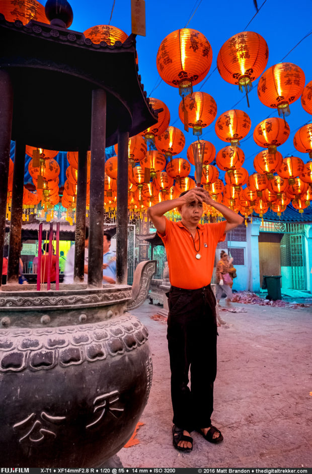 A worshiper at the worshiperKuan Yin Teng (廣福宮/觀音亭) rases his josh stick in prayer. 